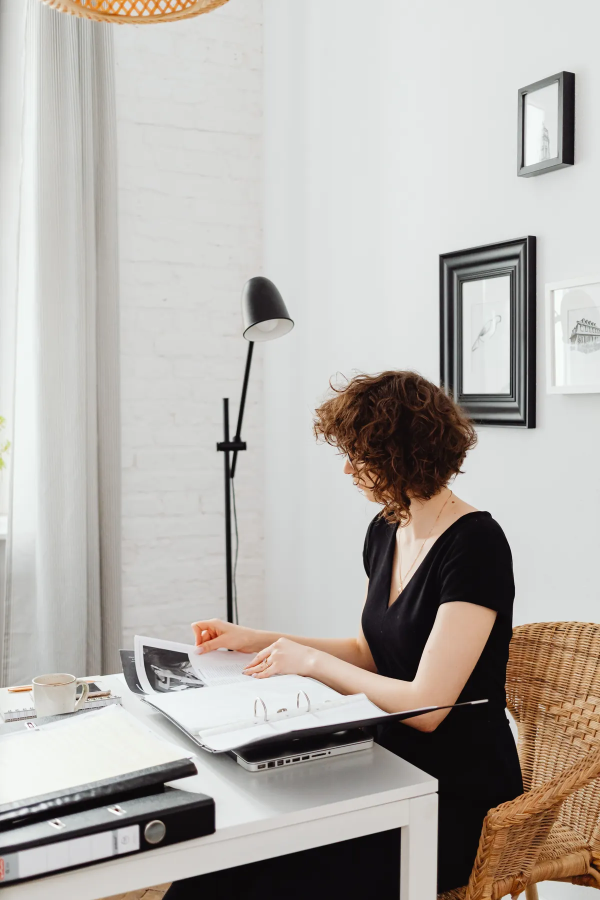 A woman reviews paperwork at a home desk.