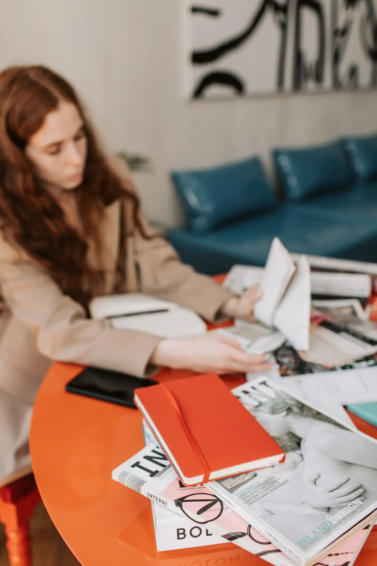 A woman reviews papers and notes at a desk.