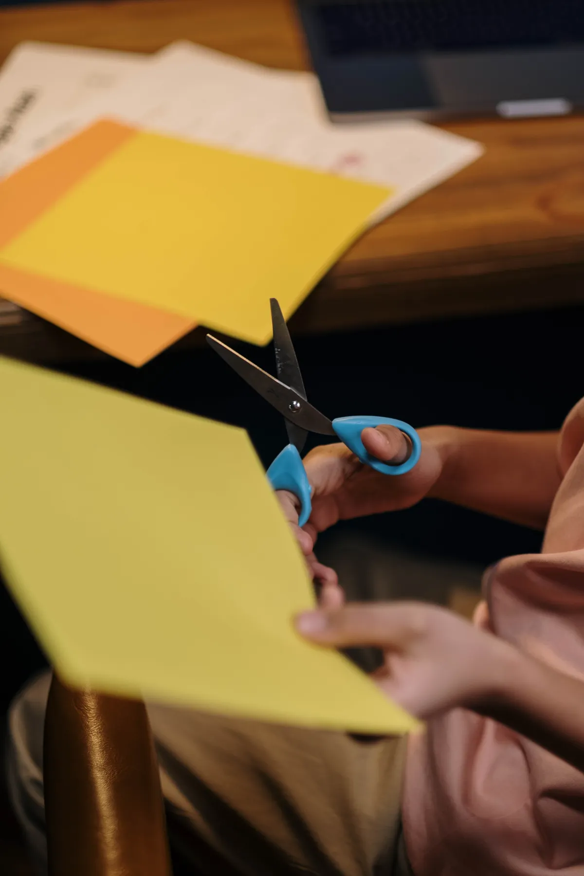 A child uses scissors to cut colored paper during a hands-on activity.