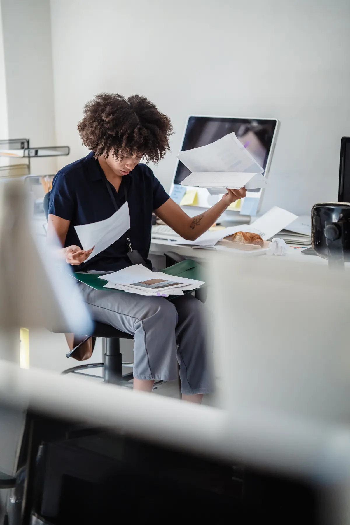 A woman reads a set of documents.