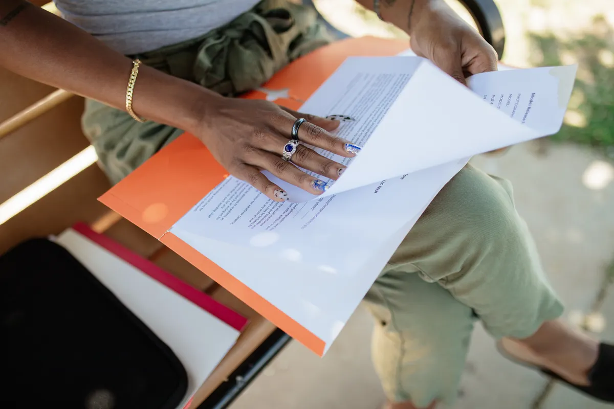 A woman checks pages in a document folder.